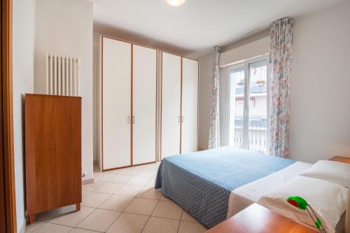 a bedroom with a bed and a large window at APPARTAMENTI SIVIGLIA in Cattolica