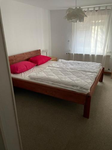 a bedroom with a bed with two red pillows at "Altes Haus" am Kurpark in den Bergen in Zorge