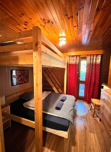 - une chambre avec des lits superposés dans une cabane en rondins dans l'établissement Duplex VUE IMPRENABLE, 2 chb, 2 Sdb, 6 pers, à La Clusaz