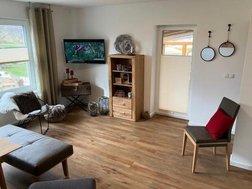 a living room with a couch and a table at Ferienwohnungen auf dem Erlenhof in Beverungen