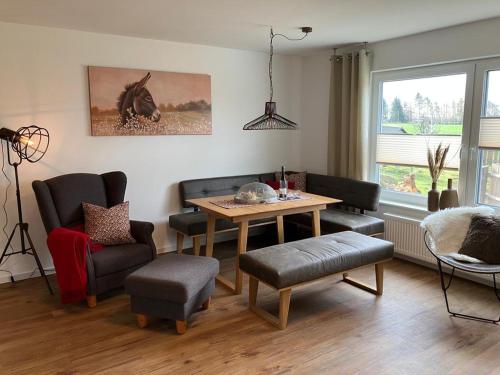 un soggiorno con tavolo e sedie di Ferienwohnungen auf dem Erlenhof a Beverungen
