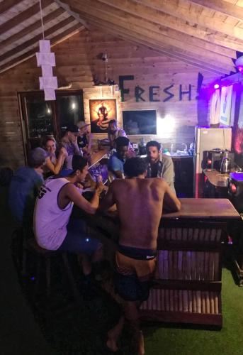a group of men standing around a bar in a restaurant at MKS - Kite & Wing Foil camp in Kalpitiya