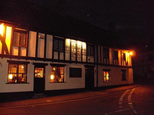 un edificio con luces en las ventanas por la noche en The George Inn, en Mere