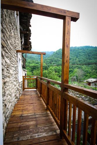 a wooden balcony with a view of the mountains at Yamabushi B&B in Gravere