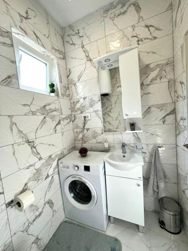 a bathroom with a washing machine and a sink at Albomi in Kotor