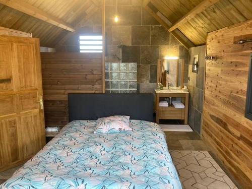 a bedroom with a bed in a wooden cabin at Le Chalet du Renard in Le Tampon