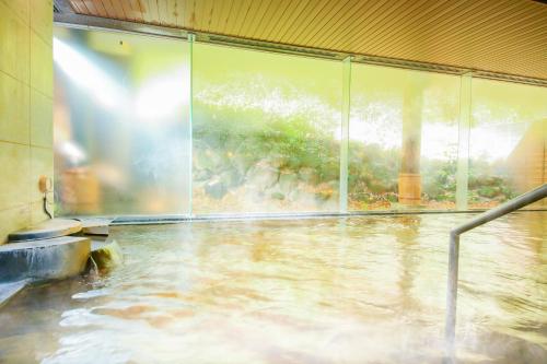 a pool of water in a room with a window at Ooedo Onsen Monogatari Premium Ikaho in Shibukawa
