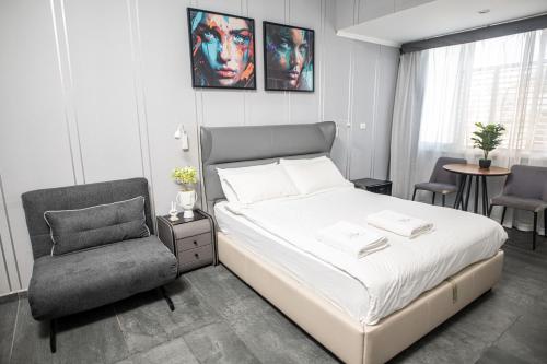 ein Schlafzimmer mit einem Bett und einem Stuhl in der Unterkunft King's rooftop in Tel Aviv