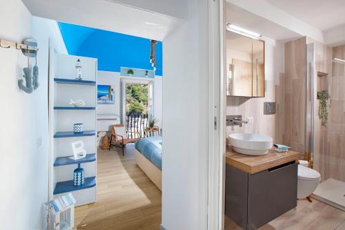 uma casa de banho com um lavatório e uma cama num quarto em Estate4home - Blu Dream Massa em Massa Lubrense