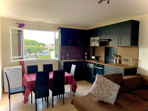 une cuisine et un salon avec une table et un canapé dans l'établissement Magnifiques chambres dans 100m2 au calme Saint Cyprien Plage, à Saint-Cyprien