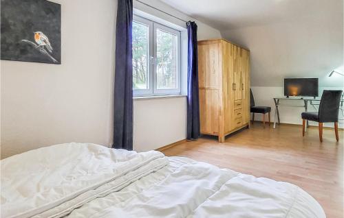 a bedroom with a bed and a desk and a window at Awesome Home In Wittstock With Kitchen in Wittstock