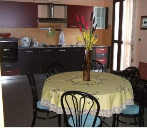 eine Küche mit einem Tisch und einer Blumenvase darauf in der Unterkunft Affittacamere Su Padru in Ittiri