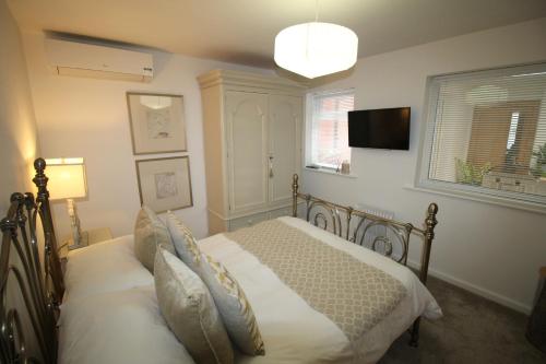 a bedroom with a bed and a flat screen tv at The Bungalow in Lytham St Annes