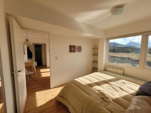 una camera con un grande letto e una grande finestra di Gente del Sur - Policarpo a Ushuaia