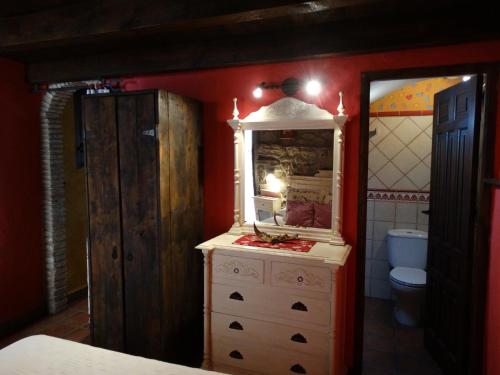 a bathroom with a dresser with a mirror and a toilet at Casa La Cantonera con zona relax jacuzzi in La Cuba