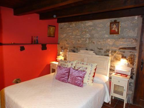 a bedroom with a bed and a stone wall at Casa La Cantonera con zona relax jacuzzi in La Cuba