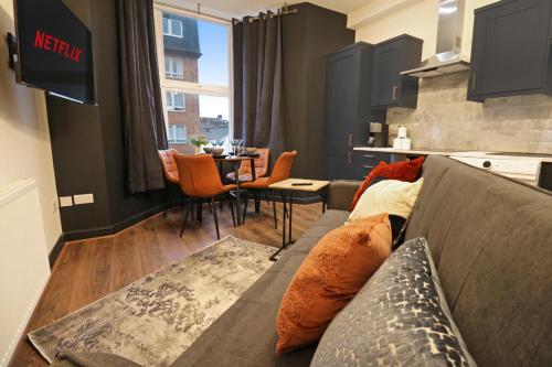 a living room with a couch and a table at Black Pearl Stays - Saltburn Apartments in Saltburn-by-the-Sea