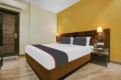 Collection O Hotel Royal Jihaan في لوديانا: غرفة نوم بسرير كبير وطاولة