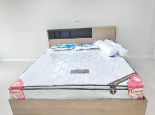 a bed with a wooden frame with two towels on it at คอนโดงามวดีเพลส ชั้นสูง วิวสวย in Ban Lat Tanot