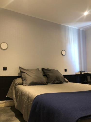 1 dormitorio con 1 cama con 2 relojes en la pared en Les Portes d'Or, en Nancy