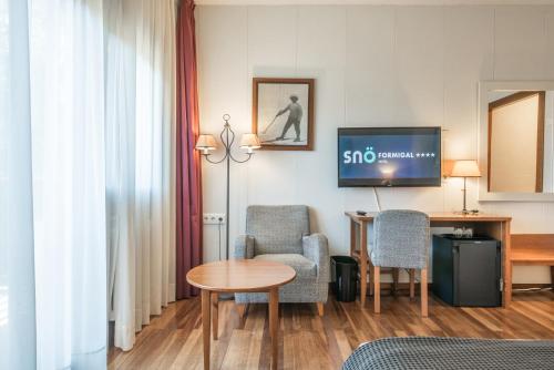a hotel room with a table and chairs and a tv at Snö Hotel Formigal in Formigal