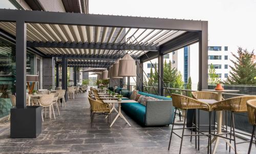a patio with tables and chairs on a building at Ilunion Atrium in Madrid