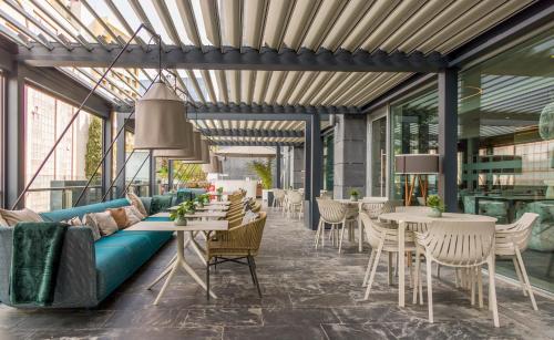 a living room with a couch and tables and chairs at Ilunion Atrium in Madrid