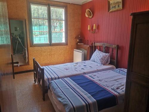 - 2 lits dans une chambre aux murs rouges dans l'établissement Maison traditionnelle sur les collines Niçoises, à Nice