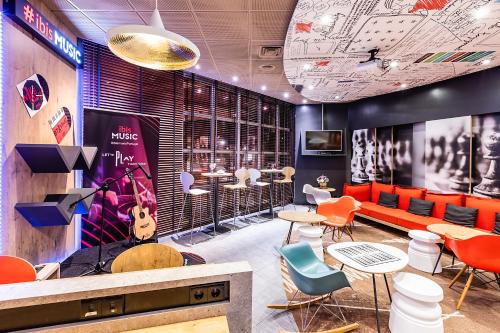 a restaurant with orange and blue chairs and tables at Hotel ibis Porto Gaia in Vila Nova de Gaia