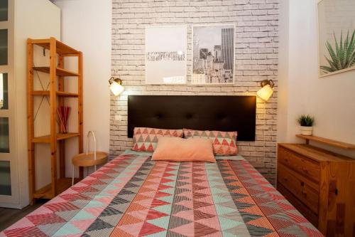 a bedroom with a bed and a brick wall at Yate 4, primera linea de playa. in Fuengirola