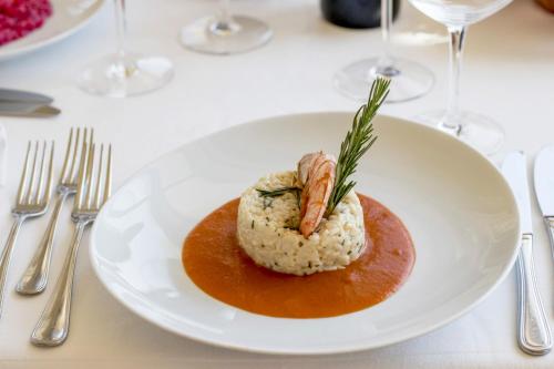 a plate of food with a shrimp on top of rice at Hotel Apollonia in Lido di Savio