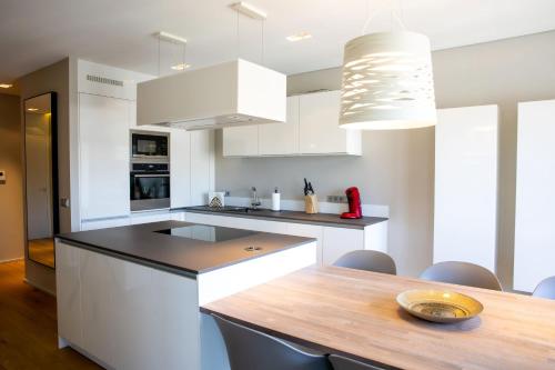 uma cozinha com armários brancos e uma mesa de madeira em Core Luxembourg City- Luxury Brands Street em Luxemburgo