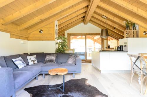 un salon avec un canapé bleu et une table dans l'établissement Chalet Makalu, aux Gets