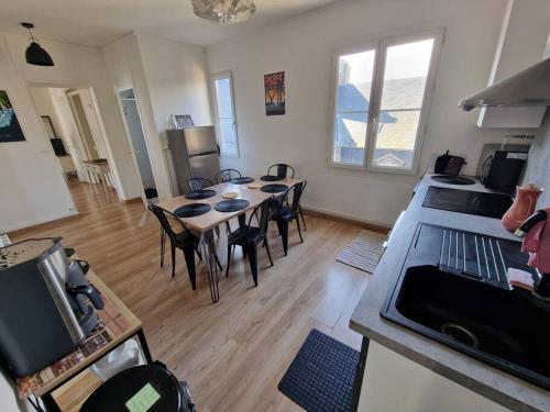 une cuisine et une salle à manger avec une table et des chaises dans l'établissement Le Carillon Dieppois, à Dieppe