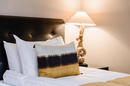 a bed with a pillow and a lamp on it at Hotel F6 in Helsinki