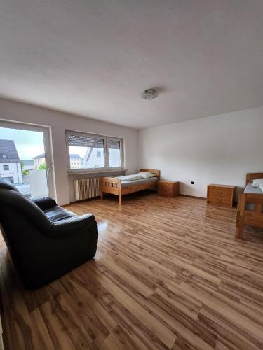 an empty living room with a couch and a bed at Stadthostel in Töging am Inn