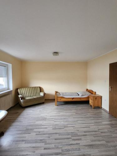 an empty room with a couch and a bed in it at Stadthostel in Töging am Inn