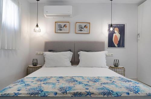 a bedroom with a large bed with white sheets at Medusa Luxury Apartments in Néa Péramos