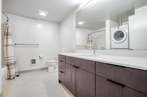 La salle de bains est pourvue d'un lavabo et d'un lave-linge. dans l'établissement Pioneer Sq 1BR w WD Gym BBQ Sound view SEA-157, à Seattle