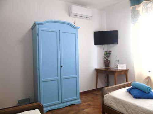 a blue cabinet in a room with a bed at Casa Vacanza LiHele - Locazione Turistica in Castelsardo