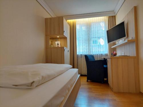 a hotel room with a bed and a desk and a television at Flair Hotel zum Schiff in Meersburg