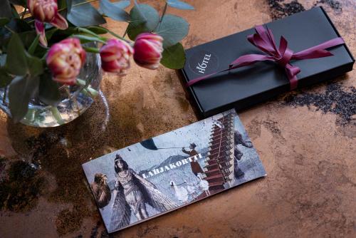 a book on a table next to a vase with flowers at Hotel F6 in Helsinki