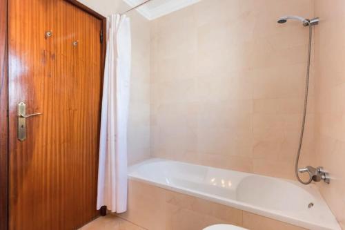 a bathroom with a bath tub and a toilet at Apartamento Férias Lagos in Lagos