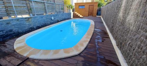 a swimming pool sitting on a patio next to a building at Villa climatisée avec piscine proche de la mer in Torreilles