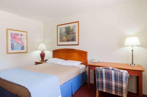 een hotelkamer met 2 bedden en een bureau bij Days Inn by Wyndham Castaic Six Flags Magic Mountain in Castaic