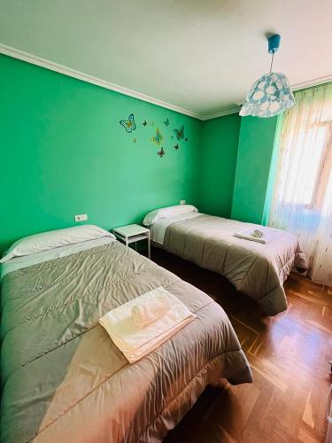 two beds in a room with green walls at Coto Carcedo in Salinas