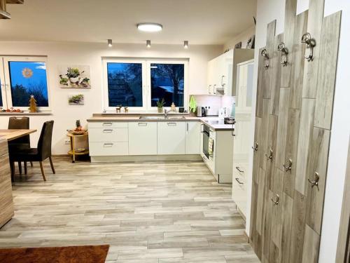 a kitchen with white cabinets and a table and a counter at Traumhaftes Ferienhaus – perfekt für Familien in Schlüchtern