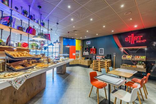 a fast food restaurant with a counter with food on it at Hotel ibis Porto Gaia in Vila Nova de Gaia