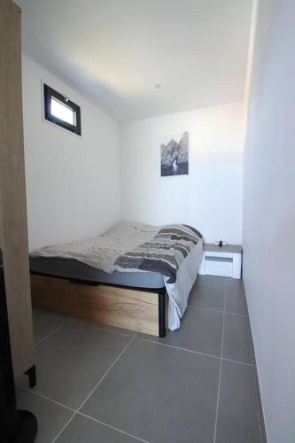 une chambre avec un lit dans une pièce blanche dans l'établissement T2 VILLAS ACUM 4 pers-Agosta PLAGE- parking, à Albitreccia