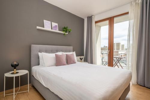 een slaapkamer met een groot wit bed en een balkon bij Vagabond Downtown in Boedapest